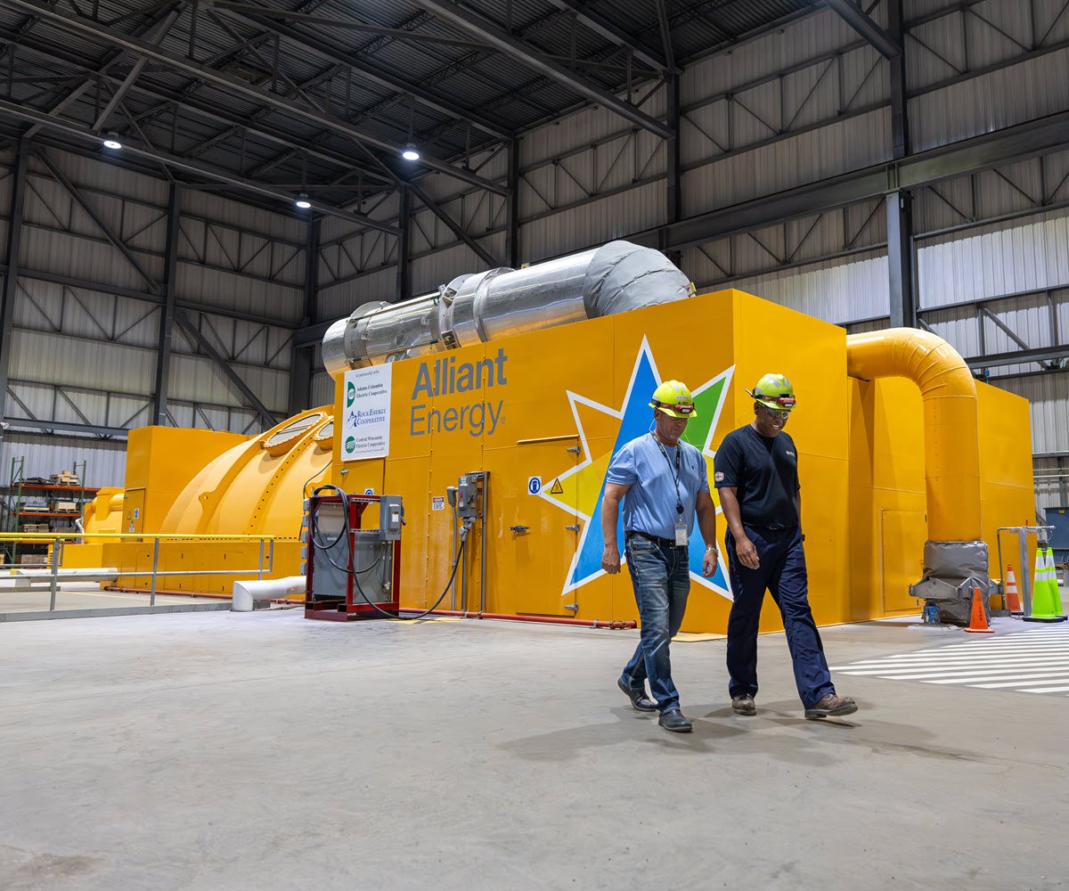 two employees walking near an orange turbine at West Riverside