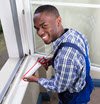 man applying caulk to window